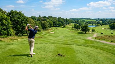 Man swinging a golf club on a course