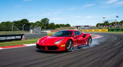 Red supercar driving fast on a race track