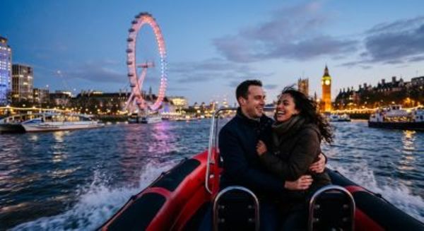 Couple enjoying a twilight speedboat ride on the River Thames