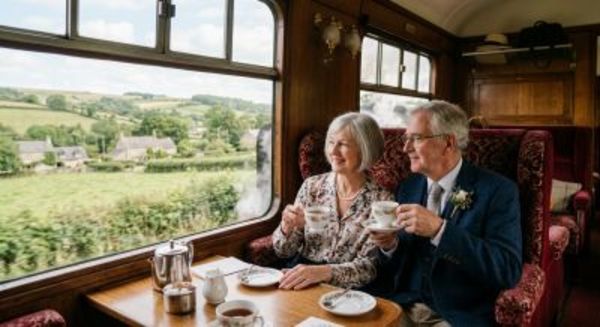 Older couple enjoying tea on a vintage steam train