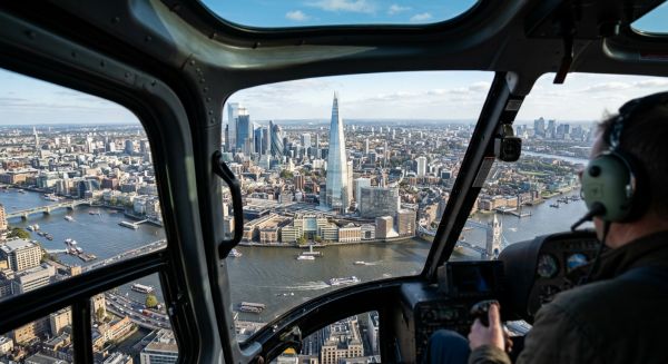 A sightseeing helicopter flying over the London skyline and the River Thames