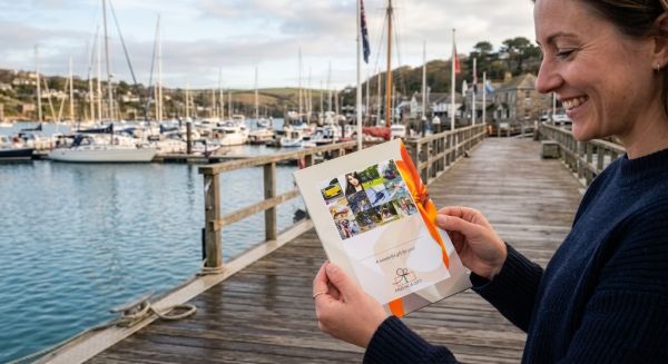 Person holding a gift voucher by a marina