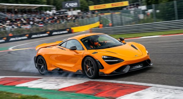Orange McLaren turning a corner on a race track