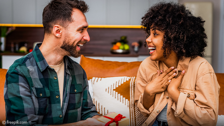 Happy couple exchanging gift at home – romantic surprise, relationship celebration, love and special moment