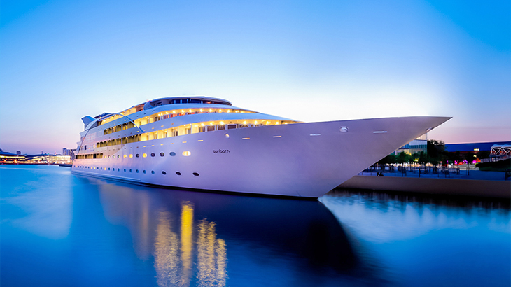 Luxury yacht at sunset on vibrant blue water – premium overnight stay and afternoon tea experience, perfect romantic wedding gift idea