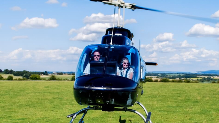 Helicopter taking off with happy passenger and pilot, thrilling helicopter ride gift experience for adventure seekers